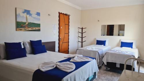 two beds in a room with blue and white at Hotel Camocim in Camocim