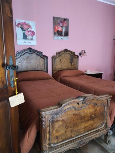 two beds in a bedroom with red sheets at Casale Villa Rainò in Gangi
