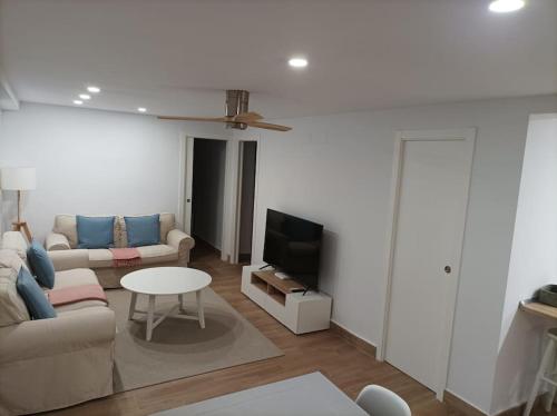 Precioso Apartamento en San Fernando في سان فرناندو: غرفة معيشة مع أريكة وتلفزيون