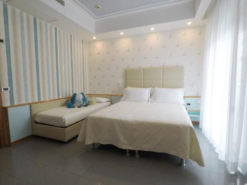 a hotel room with two beds and a window at Hotel Gaby in Rimini