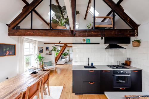 a kitchen with black cabinets and a wooden table at Railway Forge Loft in Haarlem