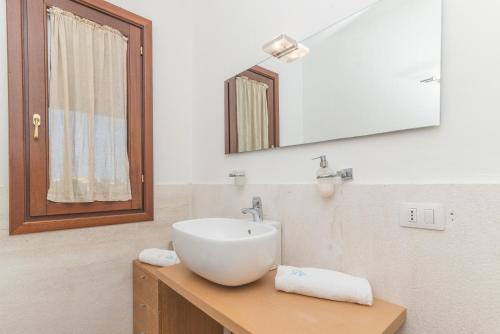y baño con lavabo blanco y espejo. en Golfo Aranci - Gli Orizzonti 26, en Golfo Aranci