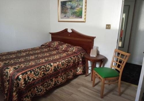 ein Hotelzimmer mit einem Bett und einem Stuhl in der Unterkunft Empress Hotel in New Orleans