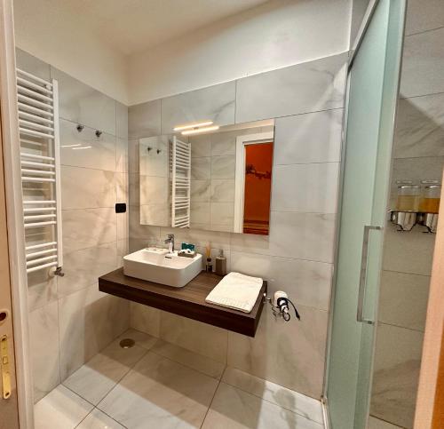 een witte badkamer met een wastafel en een douche bij Casa Santangelo Suites in Salerno
