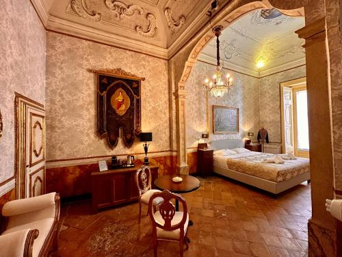 Un dormitorio con una cama y una mesa. en Casa Santangelo Suites en Salerno