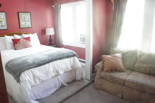 a bedroom with a bed and a window and a couch at The Frogtown Inn in Canadensis