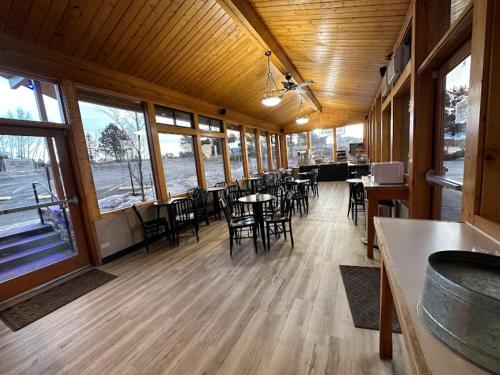 a dining room with tables and chairs and windows at Blue Door Inn in Estes Park