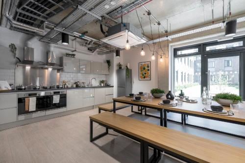 a large kitchen with wooden tables in it at Studios and Ensuite Bedrooms with Shared Kitchen at Riverside in Canterbury in Canterbury