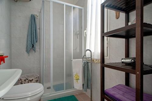 a bathroom with a toilet and a glass shower at Casina di Alo e Ala in Livorno