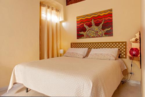 a bedroom with a bed and a painting on the wall at Casina di Alo e Ala in Livorno