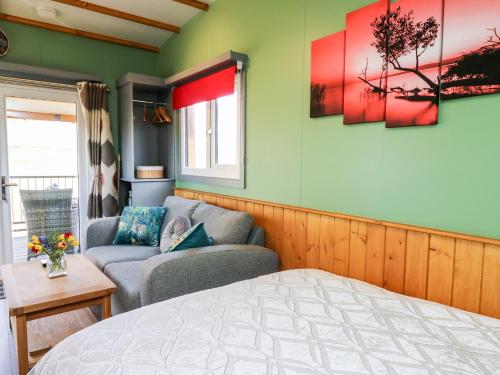 a bedroom with a bed and a couch at Wild Acre in Llangadog