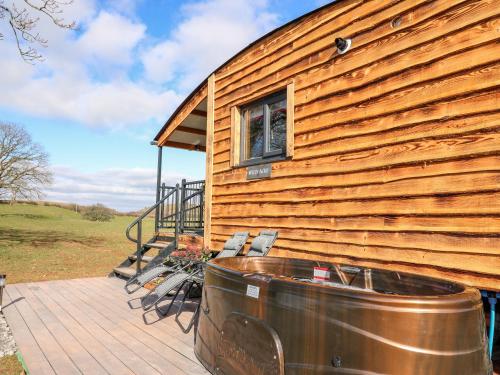 a house with a hot tub on a deck at Wild Acre in Llangadog