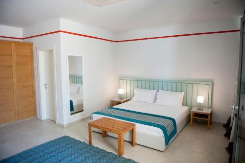 a bedroom with a bed and a table in it at Soleil Village & Villas in Jal