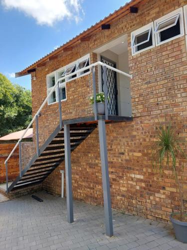 a brick house with a staircase in front of it at Stay@603 Guesthouse in Pretoria