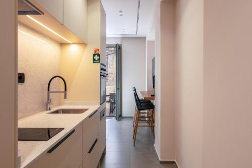 una cocina con armarios blancos y fregadero en Old City Apartments, en Heraclión