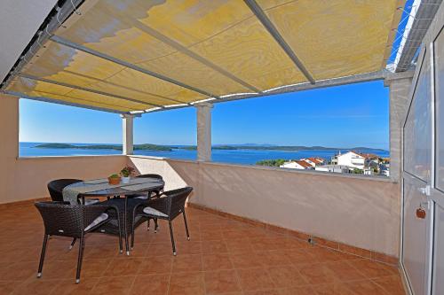 uma varanda com mesa e cadeiras e vista para o oceano em Apartments Biba Hvar em Hvar