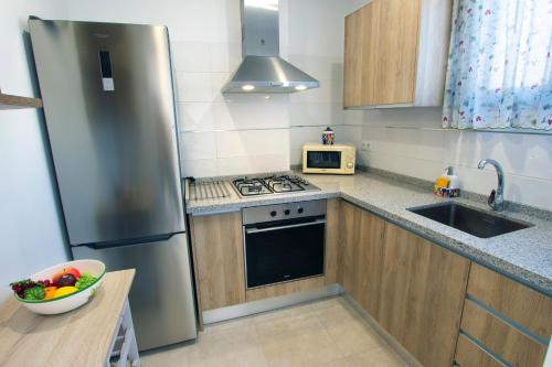 eine Küche mit einem Kühlschrank aus Edelstahl und einer Schale Obst in der Unterkunft F&M 'con terraza y tranquilidad' in La Laguna