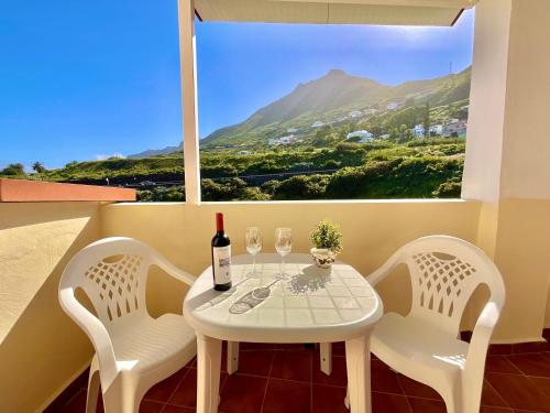 een witte tafel met 2 stoelen en een fles wijn bij F&M 'con terraza y tranquilidad' in La Laguna
