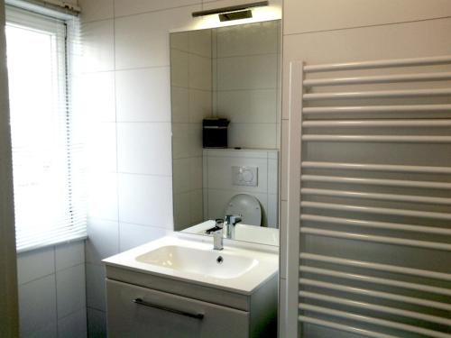 bagno con lavandino e specchio di Pension TimeOut a Kassel