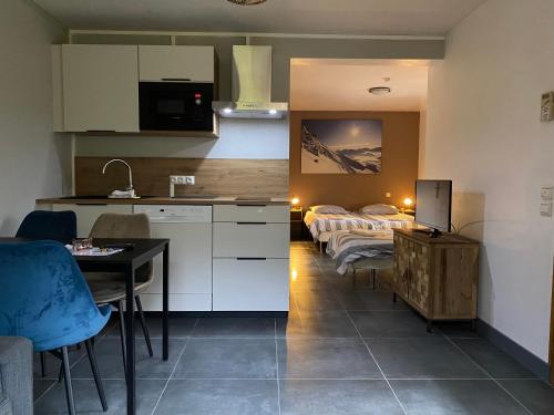 a kitchen with two beds and a table and chairs at Le Chalet Carpe Diem in Le Bourg-dʼOisans