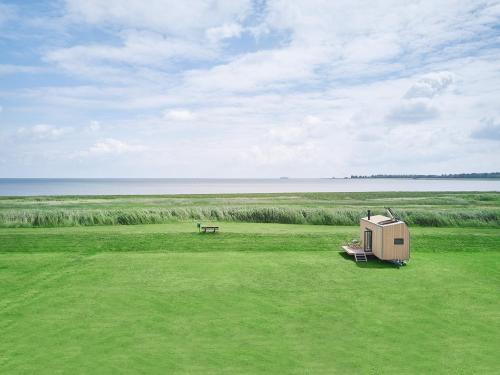 a campsite with a picnic table and a bench in a field at Tiny House Pioneer 2 - Hooksiel im Wangerland in Wangerland