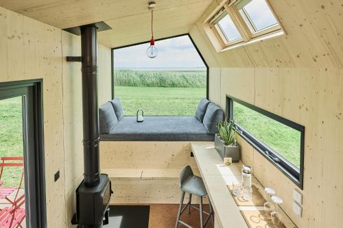 a tiny house with a bench and a stove at Tiny House Pioneer 2 - Hooksiel im Wangerland in Wangerland