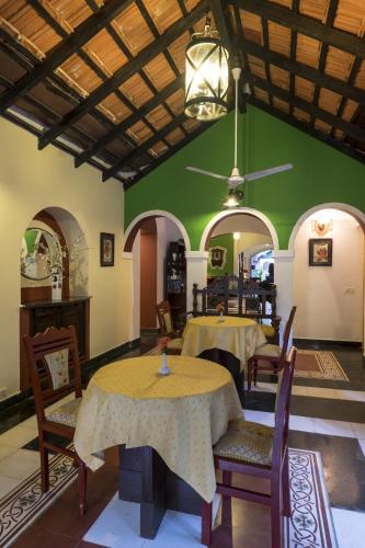 a room with two tables and chairs and a green wall at Casa Anjuna in Anjuna