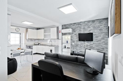 a living room with a couch and a kitchen at BmyGuest - Cascais Beach Villa I in Cascais