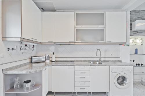 a white kitchen with a sink and a dishwasher at BmyGuest - Cascais Beach Villa I in Cascais