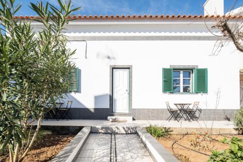 a white house with green shutters and a patio at BmyGuest - Cascais Beach Villa I in Cascais