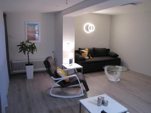 a living room with a couch and a table at FeWo-Möwenpaar-Norden-Norddeich in Norden