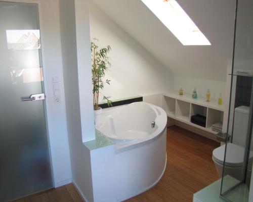 a white bathroom with a tub and a toilet at FeWo-Möwenpaar-Norden-Norddeich in Norden