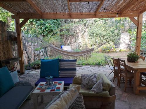 a patio with a hammock and a table and chairs at Galilean villa with jacuzzi in Qiryat ‘Amal