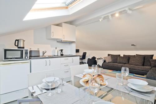 a kitchen and a living room with a table with wine glasses at BmyGuest - Cascais Beach Villa II in Cascais
