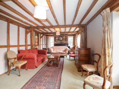 a living room with a red couch and chairs at Paythorne Farmhouse in Henfield