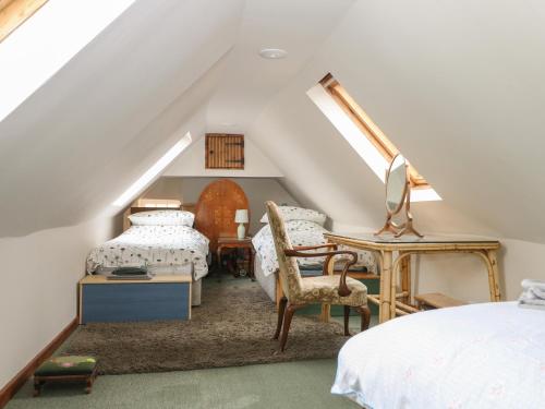Schlafzimmer im Dachgeschoss mit einem Bett und einem Schreibtisch in der Unterkunft Paythorne Farmhouse in Henfield