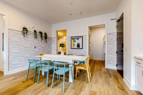 a dining room with a white table and blue chairs at Jolene on Main 402 in Nashville