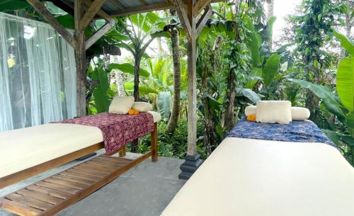 two beds sitting on the porch of a house at Hatiku Di Bali - Ubud in Tegalalang
