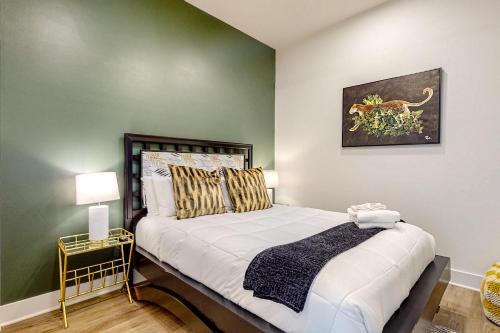 1 dormitorio con 1 cama con pared verde en Jolene on Main 402 en Nashville