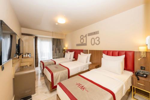 a hotel room with two beds and a television at Ramada By Wyndham Istanbul Pera Taksim in Istanbul