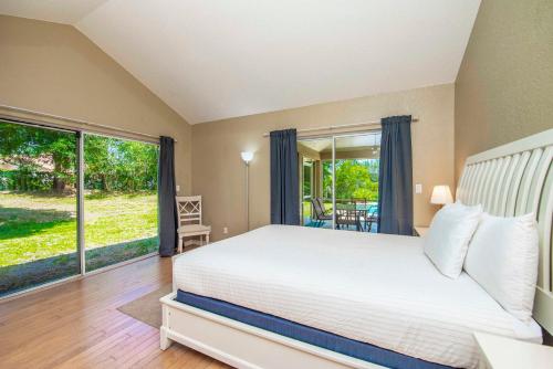 a bedroom with a bed and a large window at SWISS 65 - Lake Denise in Clermont