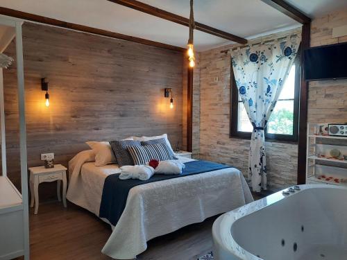 1 dormitorio con cama y bañera en Apartamento Rural Amaluna en El Torno