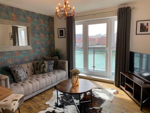 a living room with a couch and a large window at Luxury Riverfront Apartment in Newport