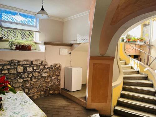 een kamer met een trap en een witte koelkast bij La Tuga appartamento stile marinaro sul mare in Imperia
