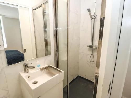 een witte badkamer met een douche en een wastafel bij "Happy Valley Boutique Accomodation" Hotel Quality, Offering Free Parking in Hebden Bridge