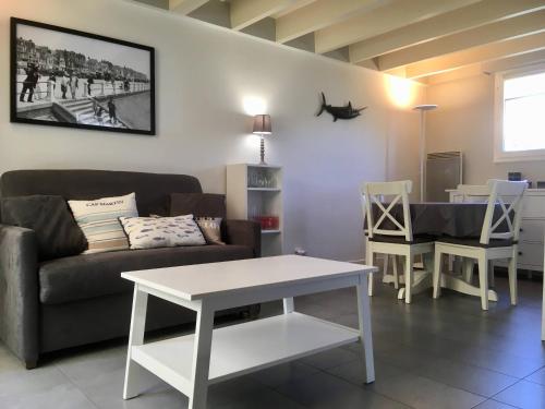 un salon avec un canapé et une table dans l'établissement Cottage au pied des dunes, à Le Touquet-Paris-Plage