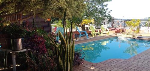 a swimming pool in a yard with chairs and plants at Indigo Chalets in Port Edward