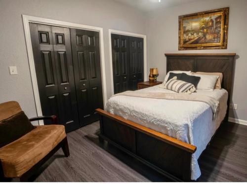 a bedroom with a bed and a chair in it at Brooklynn's Bay, Elegant Lakefront Condo Retreat in Hot Springs