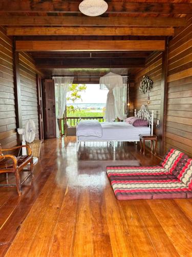 a bedroom with a bed and a couch in a room at RuenKijja in Ban Kroen
