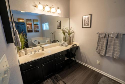 a bathroom with a sink and a large mirror at Brooklynn's Bay, Elegant Lakefront Condo Retreat in Hot Springs